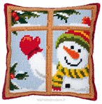 Coussin bonhomme de neige derrière la fenêtre