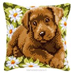 Coussin chiot labrador dans un champs de marguerites